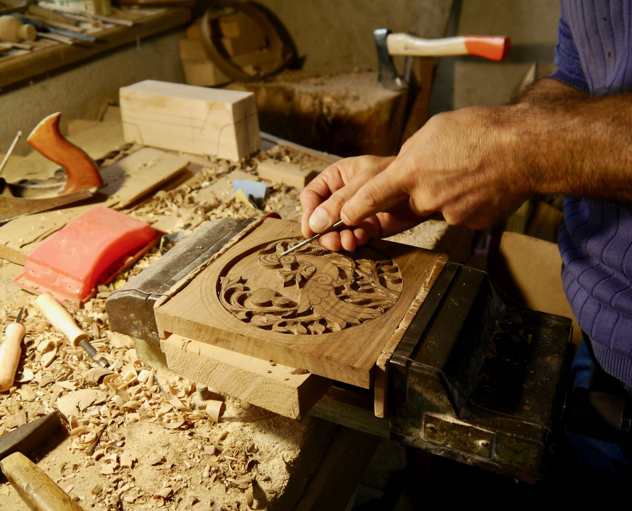 Mani di un artigiano che lavorano il legno su un banco, artigianato tradizionale armeno.